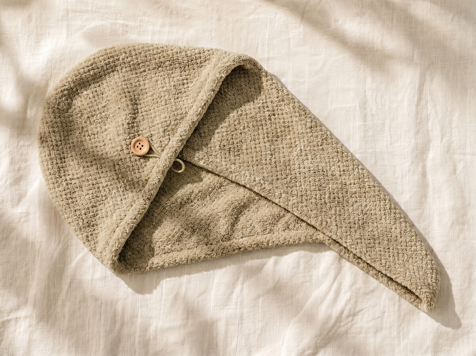 The Ablu microfibre hair towel wrap laid flat on linen