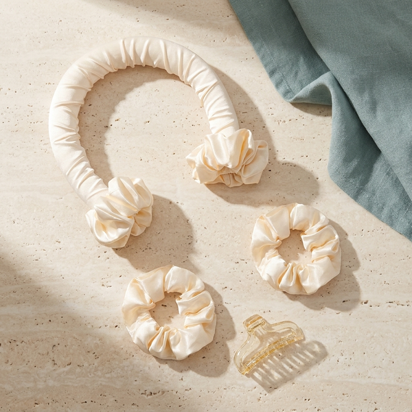 Satin heatless curling ribbon, scrunchies and clip on a travertine surface